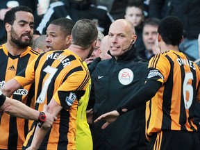 Newcastle United manager Alan Pardew (right) gestures toward Hull City players after an incident with midfielder David Meyler at the KC Stadium, March 1, 2014. (LINDSEY PARNABY/AFP)