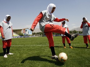 This picture taken on June 25, 2009 shows players of Iran's women national soccer team warming-up before their friendly with Malavan Anzali women's team in Tehran. (AFP PHOTO/FILES / ISNA/AMIR POORMAND)
