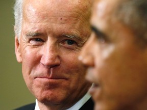 U.S. Vice President Joe Biden (L) listens as President Barack Obama speaks during a meeting with members of the Presidential Commission on Election Administration at the White House in Washington January 22, 2014. (REUTERS/Kevin Lamarque)