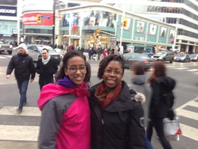 Blane Tola, 17, on the left, stands with her friend Tanesha Olagundoye, 18, at the busy Yonge-Dundas "scramble" intersection March 1, 2014. Both say the city's $100,000 plan to look into hiring staff to escort pedestrians across the street is a waste of money. (Jenny Yuen/Toronto Sun)