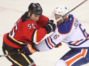 Flames Shane O'Brien (L) and Oilers Jesse Joensuu (R) battle near centre ice during NHL action between the Calgary Flames and Edmonton Oilers in Calgary, Alta. on Friday December 27, 2013 at the Scotiabank Saddledome. Jim Wells/Calgary Sun/QMI Agency