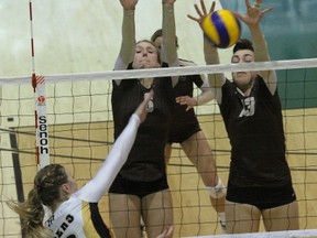Dalhousie’s Katherine Ryan (6) swings at the block of U of M’s Brittany Habing (9) and Emily Erickson during the Bisons win in the CIS national semifinal Saturday in Regina. (CHRIS ZUK/MANITOBA BISONS)