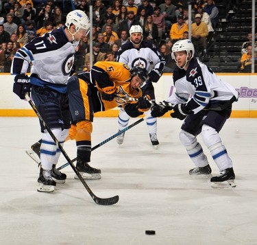 NASHVILLE, TN - MARCH 01: Michael Del Zotto #5 of the Nashville Predators is sandwhiched between James Wright #17 and Tobias Enstrom #39 of the Winnipeg Jets at Bridgestone Arena on March 1, 2014 in Nashville, Tennessee.   Frederick Breedon/Getty Images/AFP
== FOR NEWSPAPERS, INTERNET, TELCOS & TELEVISION USE ONLY ==