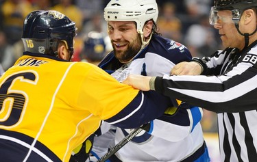 Mar 1, 2014; Nashville, TN, USA; A linesman tries to separate Nashville Predators left wing Richard Clune (16) and Winnipeg Jets defenseman Mark Stuart (5) in the second period during the hockey game at Bridgestone Arena. Mandatory Credit: Don McPeak-USA TODAY Sports