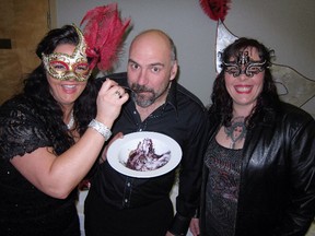 Lindsay Quintal feeds hubby Jay the last of a $5,000 cake baked by MasterChef finalist Dora Cote (right) at the Mountain Rose Women’s Shelter Masquerade Gala in Rocky Mountain House.