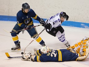Windsor?s Kenny Bradford tries to keep Western?s Matt Clarke away from a rebound as Lancers goalie Parker Van Buskirk tries to smother the puck during Game 3 of their OUA West semifinal at Thompson arena on Sunday night. The Lancers won 3-1 to take the series. (MIKE HENSEN, The London Free Press)