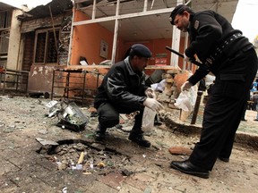 Policemen collect evidence from the site of a bomb attack at the district court in Islamabad March 3, 2014. At least 10 people, including a judge, were killed in a bomb attack on a court in the centre of the Pakistani capital Islamabad Monday, police and witnesses said. REUTERS/Faisal Mahmood