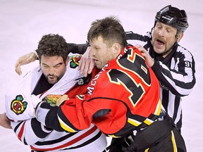 Brandon Bollig of the Chicago Blackhawks (left) scraps with Brian McGrattan of the Calgary Flames during NHL action in Calgary, Alta., Wednesday November 27, 2013. (LYLE ASPINALL/QMI Agency)
