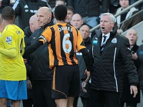 Newcastle United manager Alan Pardew (right) gestures towards Hull City players before being sent off during English Premier League action at the KC Stadium in Hull March 1, 2014. (AFP PHOTO / LINDSEY PARNABY)