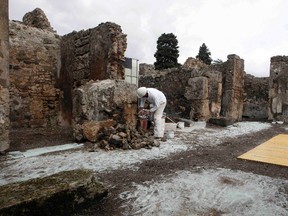 A restorer works in the ancient Roman city Pompeii, which was buried in AD 79 by an eruption of the Vesuvius volcano, February 6, 2013. (REUTERS/Ciro De Luca)