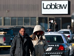Two distraught men leave a Loblaws warehouse as Edmonton Police Service officers investigate after two people were killed and four others injured in a multi-stabbing the warehouse at 16104 121A Avenue in Edmonton, Alta., on Friday, Feb. 28, 2014. Police are looking for the public's help in locating Jayme Pasieka, 29, who is said to be driving a 1999 two-door green Ford Explorer with the licence plate KEL 155. Ian Kucerak/Edmonton Sun