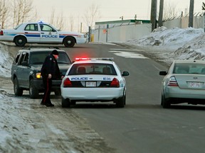 Edmonton Police Service vehicles guard a green Ford Explorer (far left) after multiple stabbing suspect 29-year-old Jayme Joshua Pasieka was arrested near 39 St., and 74 Ave., in Edmonton, Alta., on Friday, Feb. 28,  2014. Just after 2 p.m. six people were stabbed at the Loblaws warehouse at 16104 - 121A Ave., 2 people were killed. Tom Braid/Edmonton Sun/QMI Agency