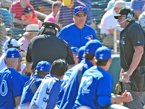 Umpires speak to the replay official as Jays manager John Gibbons looks on Monday. (USA TODAY SPORTS)