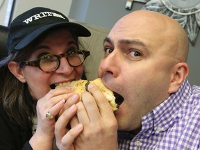 Toronto Sun Rita DeMontis (L) and James Cunningham, host of the hit TV series East St. on Food Network, chow down on a sausage in a bun concoction. Cunningham is in town to talk about his show and working with Lay's potato chips. Rita created a bunch of dishes he can try out. Thursday February 27, 2014. (Jack Boland/Toronto Sun/QMI Agency)
