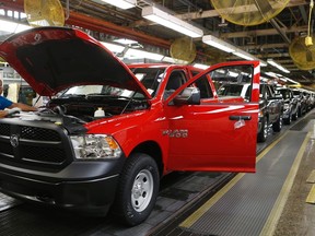 Chrysler Group assembly worker Brenda Williams checks under the hood of a 2014 Dodge Ram pickup truck for quality control at the Warren Assembly Plant in Warren, Michigan December 11, 2013. (REUTERS/Rebecca Cook)