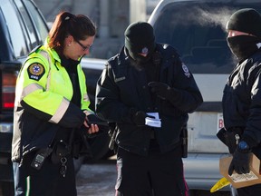 An EMS member speaks with two Edmonton Police Service officers as an investigation is underway after two people were killed and four others injured in a multi-stabbing at a Loblaws Companies Limited warehouse at 16104 121A Avenue in Edmonton, Alta., on Friday, Feb. 28, 2014. Police are looking for the public's help in locating Jayme Pasieka, 29, who is said to be driving a 1999 two-door green Ford Explorer with the licence plate KEL 155. Ian Kucerak/Edmonton Sun