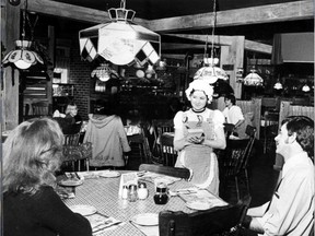 A server waits on a table, lit by the once-popular pizzeria chain?s signature Tiffany lamps, in this 1980 photo from a London eatery.