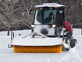 A sweeper sweeps fresh snow off the temporary skating rink at Hawrelak Park on Tuesday. (CODIE MCLACHLAN/EDMONTON SUN)