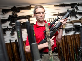 Dr. Jordan Shmidt holds one of several rifles he owns in his home south of London, Ontario on Tuesday March 4, 2014. (CRAIG GLOVER/The London Free Press/QMI Agency)