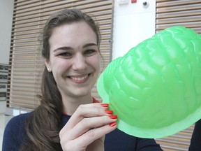 Queen's University psychology student Alex Wolfer shows the mould of a brain that is filled with Jell-O during a special presentation on the organ for elementary school students this month. The event seeks to educate the children on brain injuries and safety.
Michael Lea The Whig-Standard