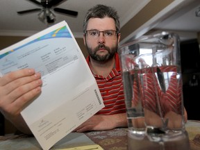 Winnipeg homeowner Ryan Black, who was without water due to frozen pipes, displays his water bill in Winnipeg, Man. Wednesday March 5, 2014. Black is in favour of compensation for those inconvenienced. (Brian Donogh/Winnipeg Sun)