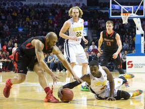 London Lightning player Tony Bennett recovers a fumbled ball as Brampton A's player Scottie Haralson moves in. (Free Press file photo)