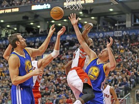 Golden State Warriors big men David Lee (right) and Andrew Bogut come up with a rebound in front of two Raptors on Sunday. (USA TODAY SPORTS)