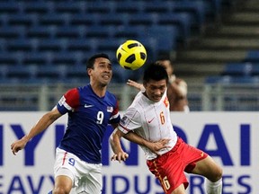 Vietnam's Tran Dinh Dong (right), seen here battling Malaysia's Norsharul Idlan bin Talaha, was banned for 28 games for breaking an opponent's leg during a game. (Bazuki Muhammad/Reuters/Files)