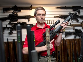 Dr. Jordan Shmidt holds one of several rifles he owns in his home south of London. Shmidt, who shoots for sport at a range, is upset over a proposed RCMP prohibition on guns that can easily be converted to be fully automatic. CRAIG GLOVER/The London Free Press/QMI Agency