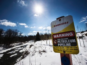 A sign warning of a high pressure petroleum pipeline is seen on the "Line 9" Enbridge oil pipeline route along the Don Rive in East Don Parkland in Toronto, March 6, 2014. (REUTERS/Mark Blinch)