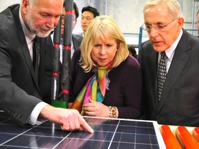 Rick Williams (left), general manager of Canadian Solar (Guelph and London), explains his company’s solar panel technology to London North Centre MPP Deb Matthews and Ontario Minister of Energy Bob Chiarelli at the grand opening of the Canadian Solar Inc. manufacturing facility in London, Ont. March 6, 2014. CHRIS MONTANINI\LONDONER\QMI AGENCY