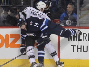 Los Angeles Kings defenceman Robyn Regehr is taken into the boards by Winnipeg Jets right winger Anthony Peluso during NHL hockey in Winnipeg, Man. Thursday, March 06, 2014. (Brian Donogh/Winnipeg Sun)