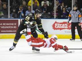 Sault Ste. Marie Greyhounds winger Sergey Tolchinksy flies through the air as London Knights defenceman Nikita Zadorov steals the puck during their Ontario Hockey League game at Budweiser Gardens Thursday. (CRAIG GLOVER, The London Free Press)