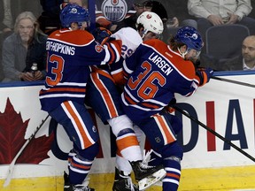 The Edmonton Oilers' Ryan Nugent-Hopkins (93) and Philip Larsen (36) collide with the New York Islanders' Brock Nelson (29) during first period NHL action at Rexall Place in Edmonton Alta., on Thursday March 6,  2014. David Bloom/Edmonton Sun/QMI Agency