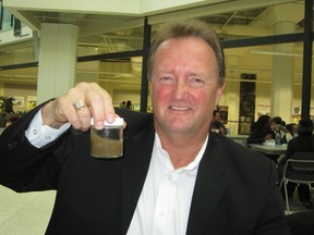 Clearflow founder Jerry Hanna holds up a sample of industrial wastewater.