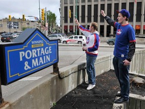 Hockey fans Cody Petrash (left) and Anthony Maluzynsky cheer at the corner of Portage and Main to celebrate the return of the Winnipeg Jets. The city is looking at options to once again open the intersection to pedestrians. (REUTERS FILE PHOTO)