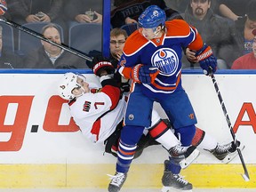 Mar 4, 2014; Edmonton; Edmonton Oilers defencemen Jeff Petry (2) takes Ottawa Senators forward Kyle Turris (7) into the boards during the first period at Rexall Place. Perry Nelson-USA TODAY Sports
