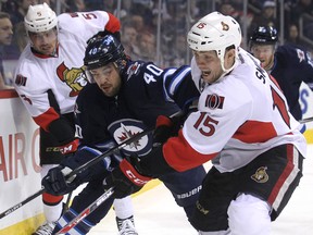 Winnipeg Jets forward Devin Setoguchi (40) and Ottawa Senators centre Zach Smith battle for the puck during NHL action at MTS Centre in Winnipeg, Man., on Sat., March 8, 2014. Kevin King/Winnipeg Sun/QMI Agency