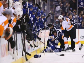 Players from both benches lean over for a better look as Maple Leafs’ Frazer McLaren squares off with Flyers (and former Toronto) enforcer Jay Rosehill last night at the Air Canada Centre. Both players received five-minute majors for their efforts. (Jack Boland/Toronto Sun)