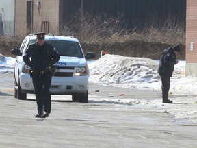 Toronto Police officers are pictured Sunday behind the Tibetan Canadian Cultural Centre on Sunday following a fatal stabbing. (JACK BOLAND, Toronto Sun)