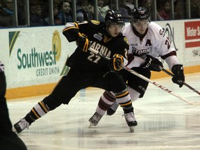 Sarnia Sting forward Nikolay Goldobin (in black) gets tangled with Guelph Storm forward Brock McGinn as they battle for the puck during their game on Sunday, March 9. Sarnia lost the game 6-2. SHAUN BISSON/THE OBSERVER/QMI AGENCY