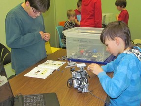 Zackary Rondeau, left, and Aidan Smith work on a Lego robot as part of a three-month program organized by First Lego League. The league also organizes a robotics competition for students./THE OBSERVER/QMI AGENCY