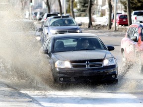 Motorists make their way through a large puddle along 98 Avenue near 79 Street in Edmonton on Sunday. (DAVID BLOOM/Edmonton Sun)