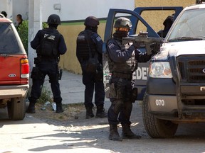 Federal police stand guard during a raid where security forces fought Nazario Moreno cartel members, as part of operations that began Wednesday evening, in Apatzingan December 10, 2010. REUTERS/Leogivildo Gonzalez