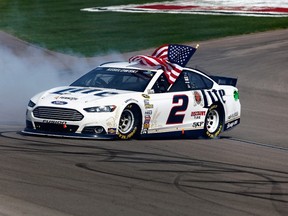 Brad Keselowski burns rubber in his Miller Lite Ford to celebrate his victory in the NASCAR Sprint Cup Series Kobalt 400 at Las Vegas Motor Speedway on Sunday. It was his second win of the weekend after taking the Nationwide race Saturday. (BRIAN LAWDERMILK/Getty Images/AFP)