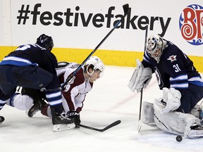 Winnipeg Jets defenceman Mark Stuart (left) and Jets goalie Ondrej Pavelec (right) stop a shot by Colorado Avalanche center Nathan MacKinnon during NHL hockey in Winnipeg, Man. Thursday, December 12, 2013.
(Brian Donogh/Winnipeg Sun/QMI Agency)