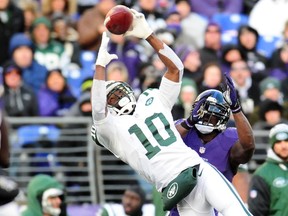 New York Jets wide receiver Santonio Holmes (10) catches the ball as Baltimore Ravens safety James Ihedigbo (32) defends at M&T Bank Stadium on Nov 24, 2013 in Baltimore, MD, USA. (Evan Habeeb/USA TODAY Sports)