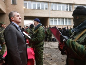 Sergei Aksyonov, Crimea's pro-Russian prime minister, stands as a member of a pro-Russian self defence unit takes an oath to Crimea government in Simferopol March 10, 2014. (REUTERS/Vasily Fedosenko)