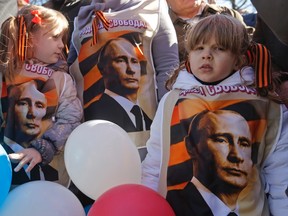 Children stand amongst people holding a rally to support Russian speakers living in Crimea and Ukraine, in central Moscow March 10, 2014. REUTERS/Maxim Shemetov