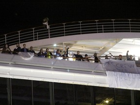Passengers wait to leave the Carnival Triumph cruise ship after reaching the port of Mobile, Alabama, February 14, 2013. (REUTERS/ Lyle Ratliff)